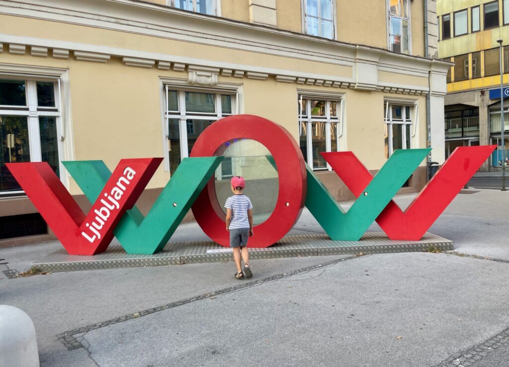 Ben Bertoni in front of the WOW Ljubljana sign in the center of Ljubljana
