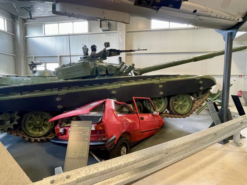 A Yugoslavian tank crushes a red Yugoslav car at the Museum of Military History Pivka, Slovenia