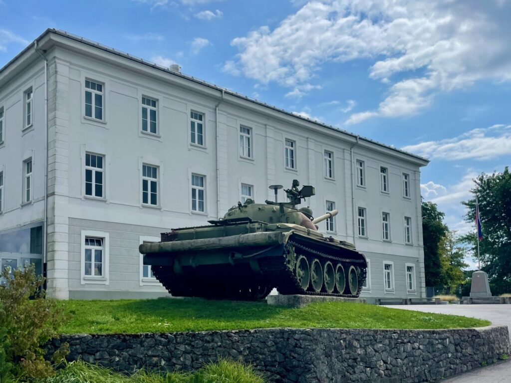 Tank in front of former military buildings at the Park of Military History in Pivka, Slovenia