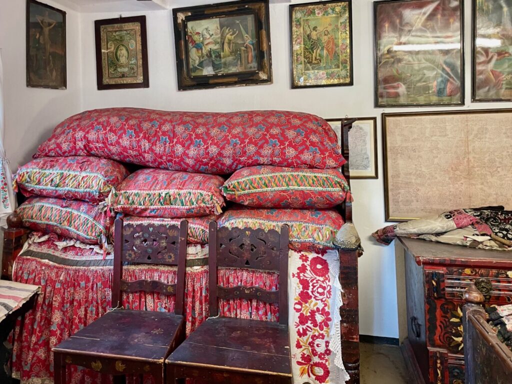 Interior of Bori Kisjankó's house, with the high bed symbolizing wealth and religious images, in Mezőkövesd