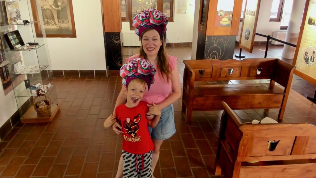Paola and Ben Bertoni wearing traditional Matyó hats in the souvenir photo at the Visitor Centre in Mezőkövesd, Hungary