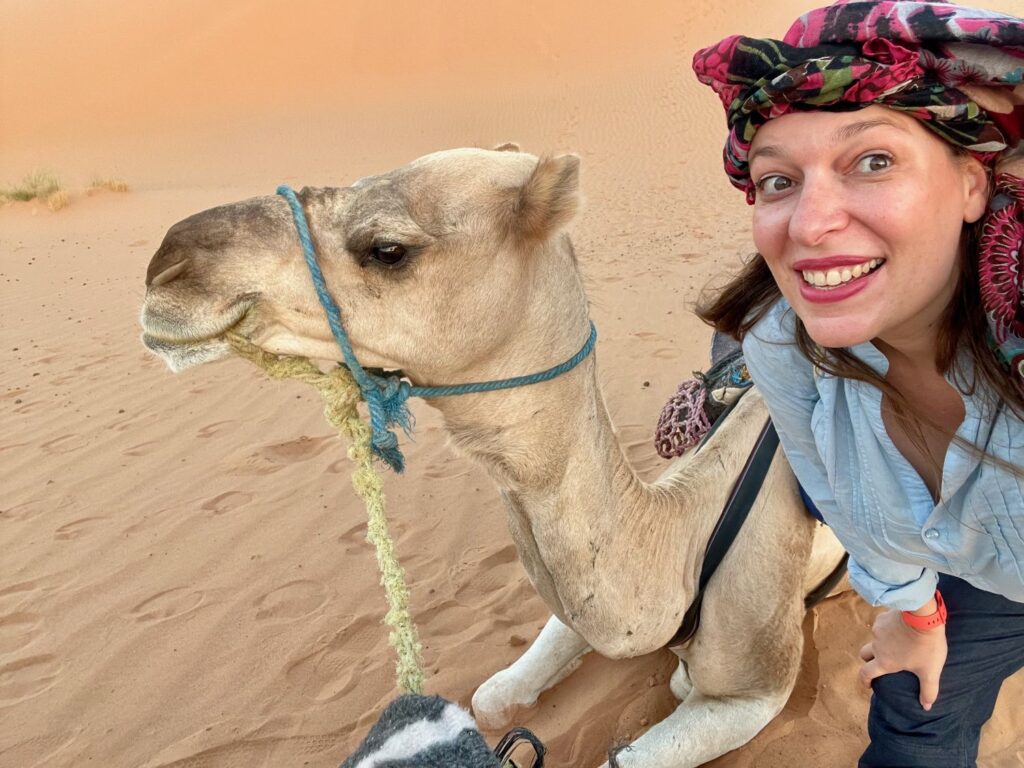 Paola Bertoni in the Moroccan desert with a camel