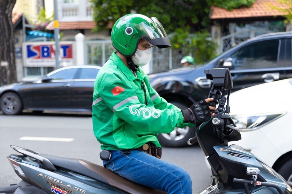 Grab driver riding a scooter in Vietnam