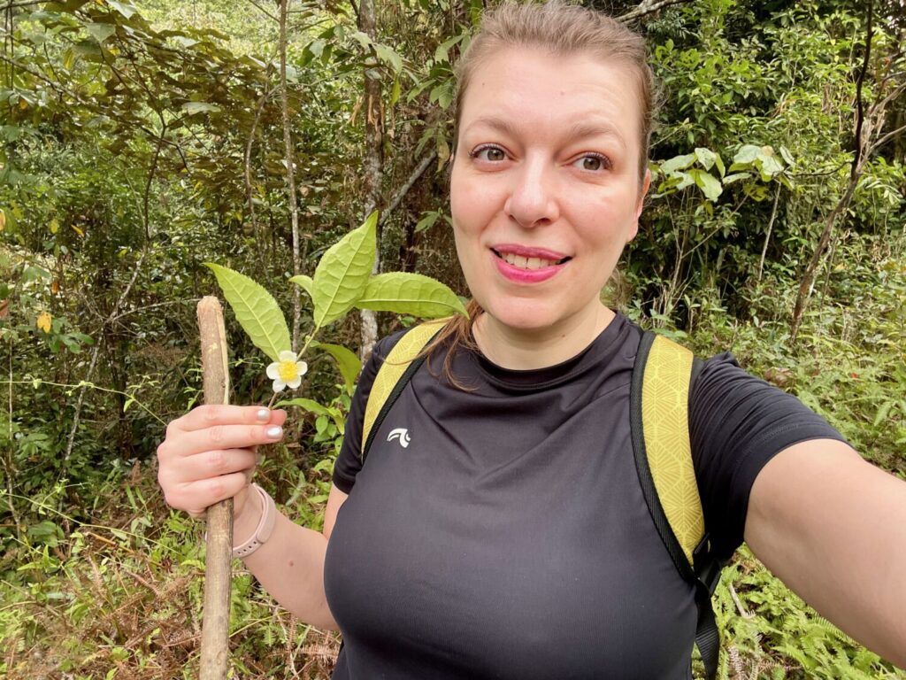 Paola Bertoni holding a tea flower during a trek in Hoang Su Phi, Vietnam