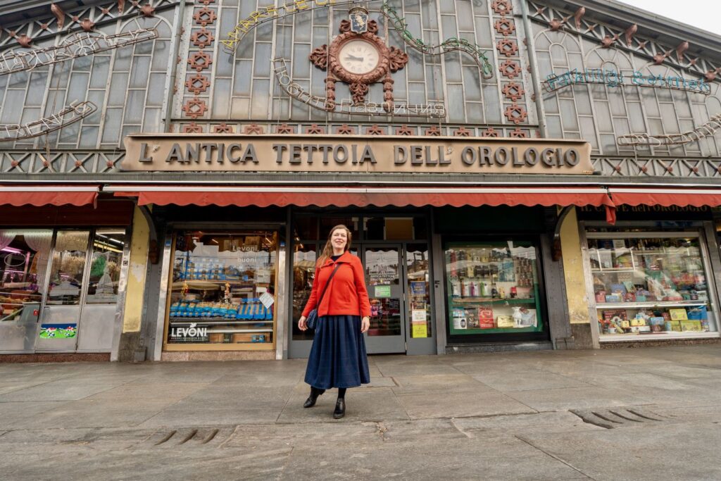 Paola Bertoni in front of the Antica Tettoia dell'Orologio at Porta Palazzo, the market of Piazza della Repubblica in Turin