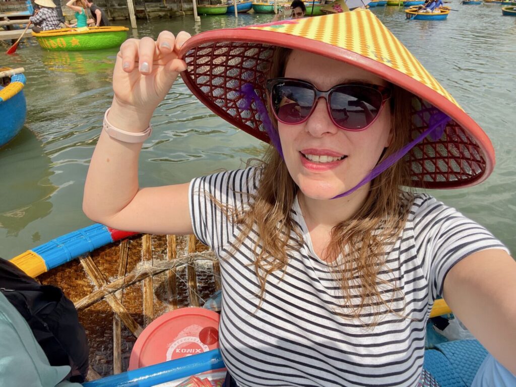 Paola Bertoni wearing a traditional Vietnamese conical hat on a boat in Cam Thanh, Vietnam
