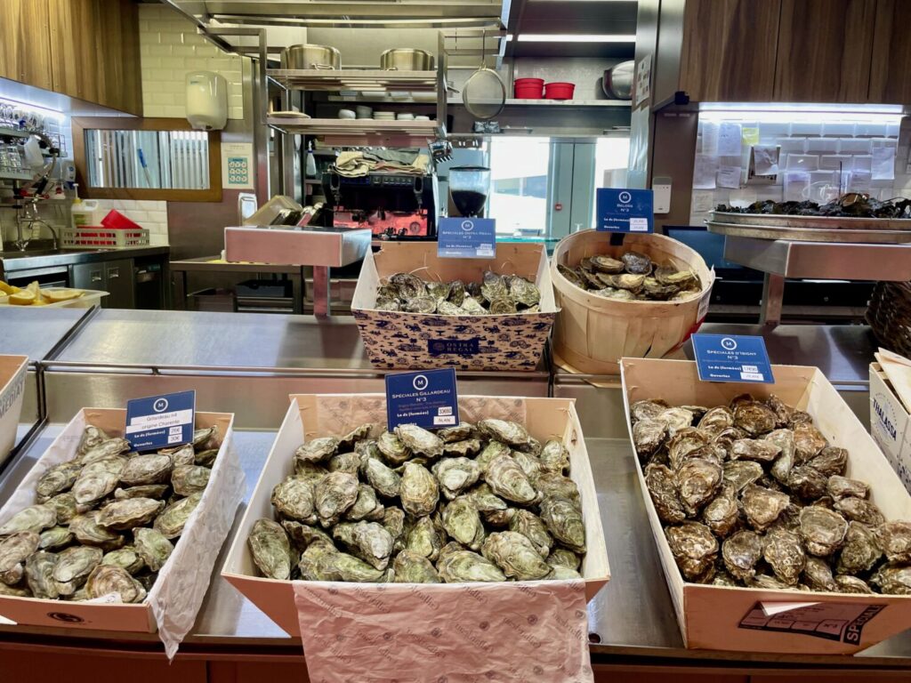 Fresh oysters displayed at the écaillers counters inside Les Halles de Lyon