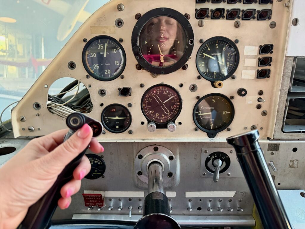 Paola Bertoni reflected in the cockpit of an old military aircraft at the Polish Aviation Museum in Kraków