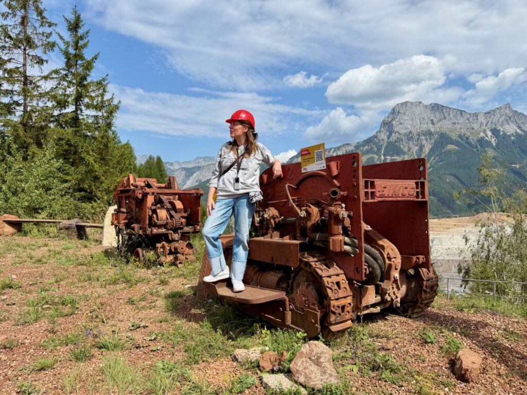 Paola Bertoni on a piece of machinery in the outdoor exhibition area of the Erzberg Mine in Eisenerz, Austria